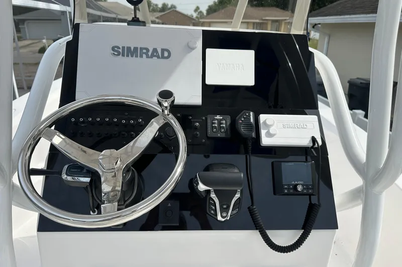 Slide: The Image of 2024 Aquasport 230 Pro Bay boat dashboard with Simrad and Yamaha controls. - 6
