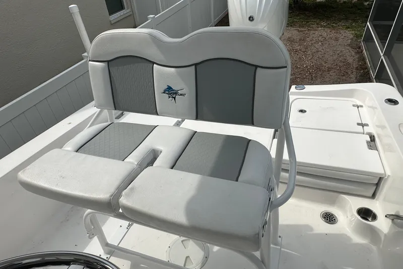Slide: The Image of 2024 Aquasport 230 Pro Bay boat seat with logo, white and gray upholstery. - 7