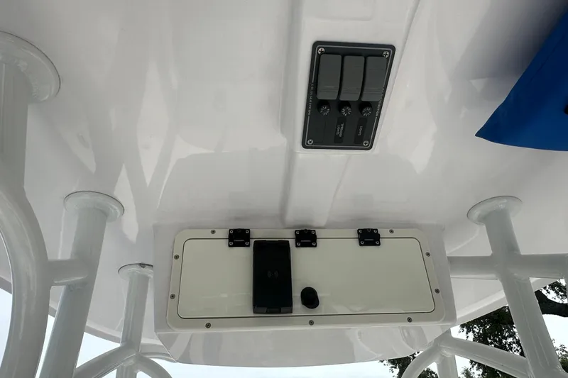 Slide: The Image of 2024 Aquasport 230 Pro Bay boat console with control panel and storage compartment. - 8