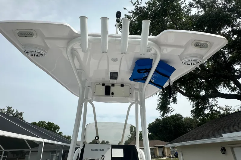 Slide: The Image of 2024 Aquasport 230 Pro Bay boat T-top with rod holders and speakers. - 9