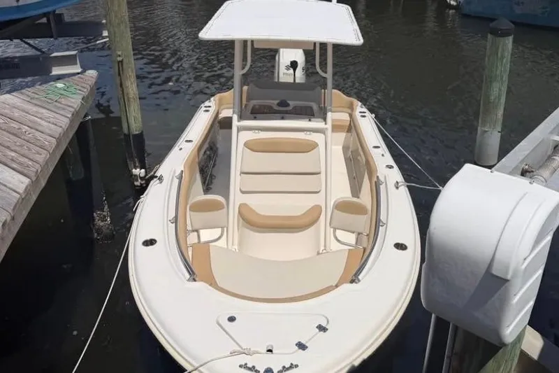 Slide: The Image of 2018 Pioneer 202 Islander boat docked in marina, featuring beige seating and white canopy. - 7