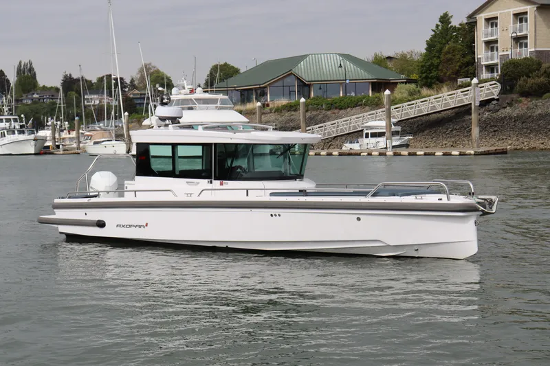 Slide: The Image of 2022 Axopar 28 Cabin boat docked in a marina, showcasing sleek design and modern features. - 1
