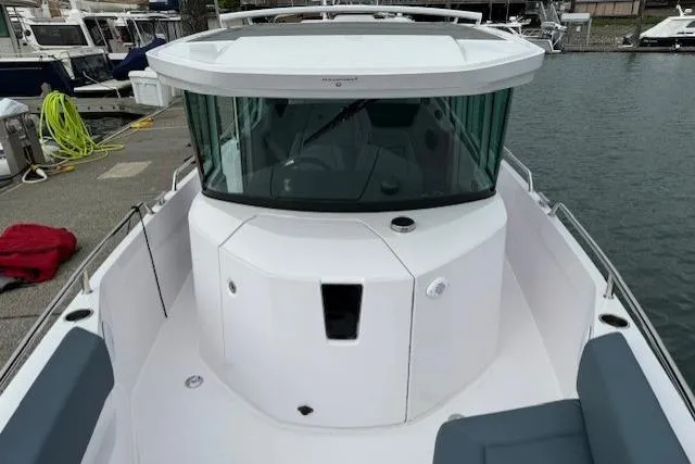 Slide: The Image of 2022 Axopar 28 Cabin boat docked at marina, featuring sleek design and spacious deck. - 10