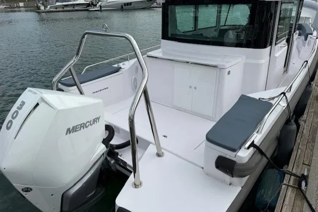 Slide: The Image of 2022 Axopar 28 Cabin boat with Mercury engine docked at marina. - 12