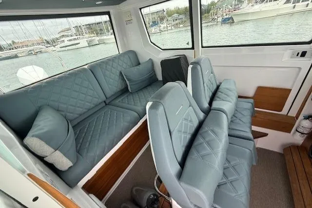 Slide: The Image of Interior of 2022 Axopar 28 Cabin boat with quilted seating and large windows. - 4