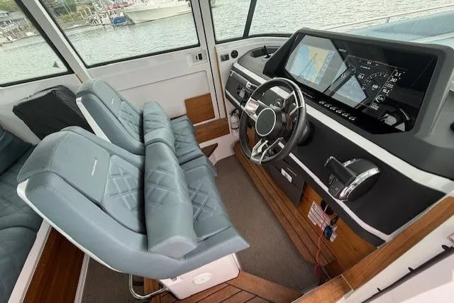 Slide: The Image of Interior of 2022 Axopar 28 Cabin boat with modern dashboard and comfortable seating. - 5