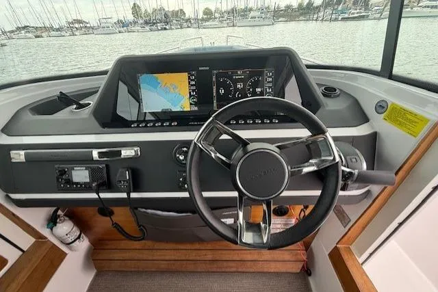Slide: The Image of Helm of 2022 Axopar 28 Cabin boat with navigation display and steering wheel. - 6