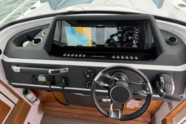 Slide: The Image of 2022 Axopar 28 Cabin dashboard with navigation display and steering wheel. - 7