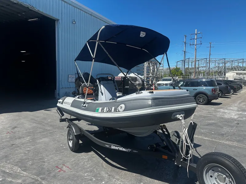 Slide: The Image of 2021 Highfield Sport 360 boat on trailer outside warehouse. - 2