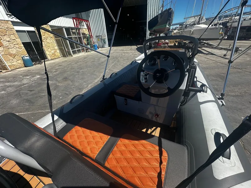 Slide: The Image of Interior view of a 2021 Highfield Sport 360 boat with steering wheel and seating. - 9