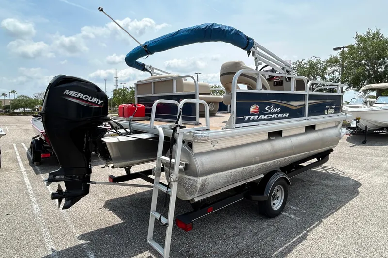 Slide: The Image of 2020 Sun Tracker Bass Buggy 16 DLX pontoon boat with Mercury outboard motor on trailer. - 4
