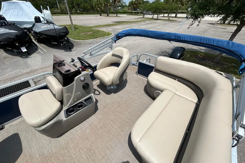 Slide: The Image of 2020 Sun Tracker Bass Buggy 16 DLX pontoon boat interior with beige seating and helm. - 6