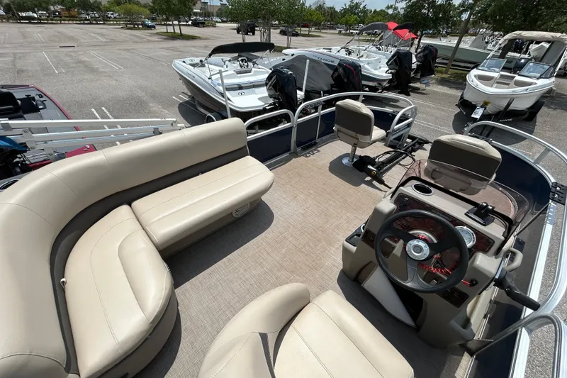 Slide: The Image of 2020 Sun Tracker Bass Buggy 16 DLX pontoon boat with beige seating in a parking lot. - 7
