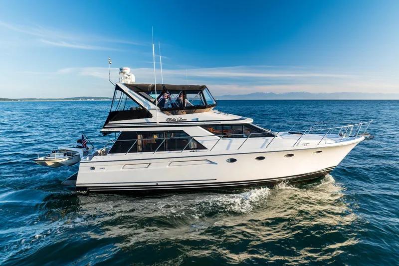 Slide: The Image of Ocean Alexander 48 Sedan yacht cruising on open sea, 1990 model, under clear blue sky. - 14