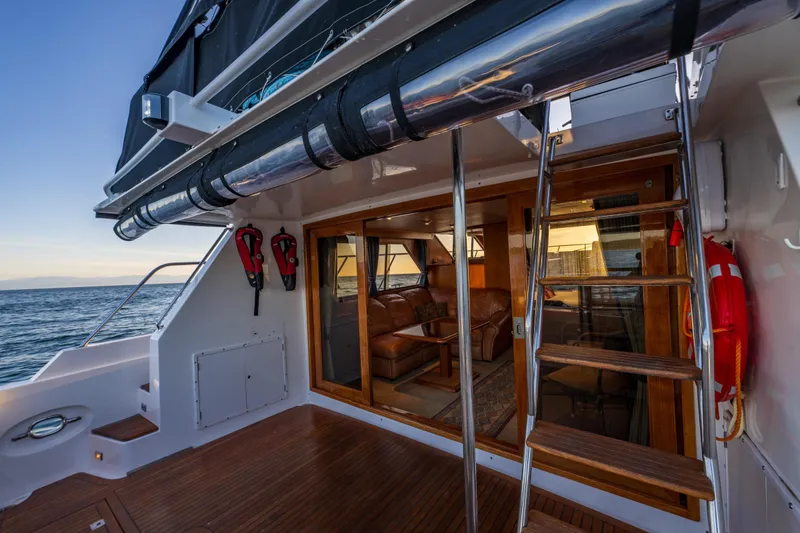Slide: The Image of Ocean Alexander 48 Sedan 1990 yacht deck with wooden stairs and ocean view. - 18