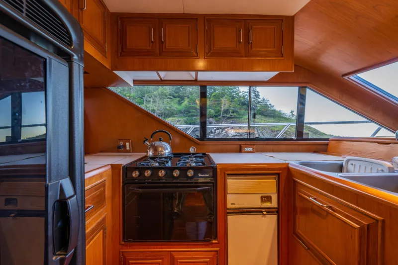 Slide: The Image of Cozy kitchen interior of 1990 Ocean Alexander 48 Sedan yacht with scenic window view. - 40