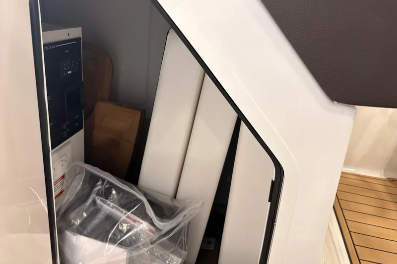 Slide: The Image of Interior storage compartment of 2026 Searay 290 SDX boat, featuring electrical panel. - 12