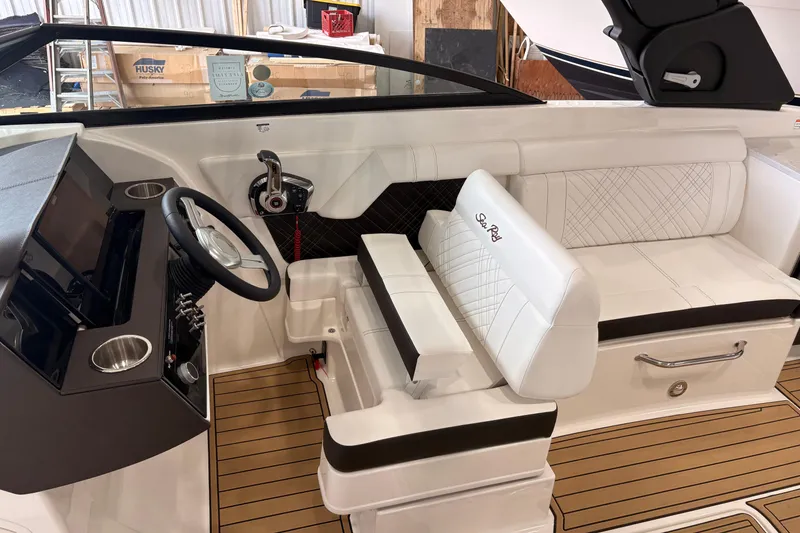 Slide: The Image of 2026 Searay 290 SDX boat interior with steering wheel and white seating. - 16