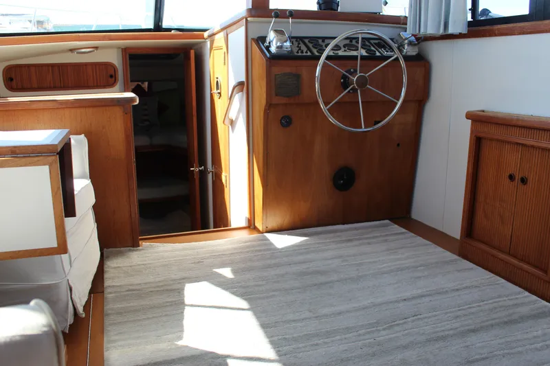Slide: The Image of Interior of 1990 Carver 3207 Aft Cabin Motor Yacht with wooden helm and seating area. - 13