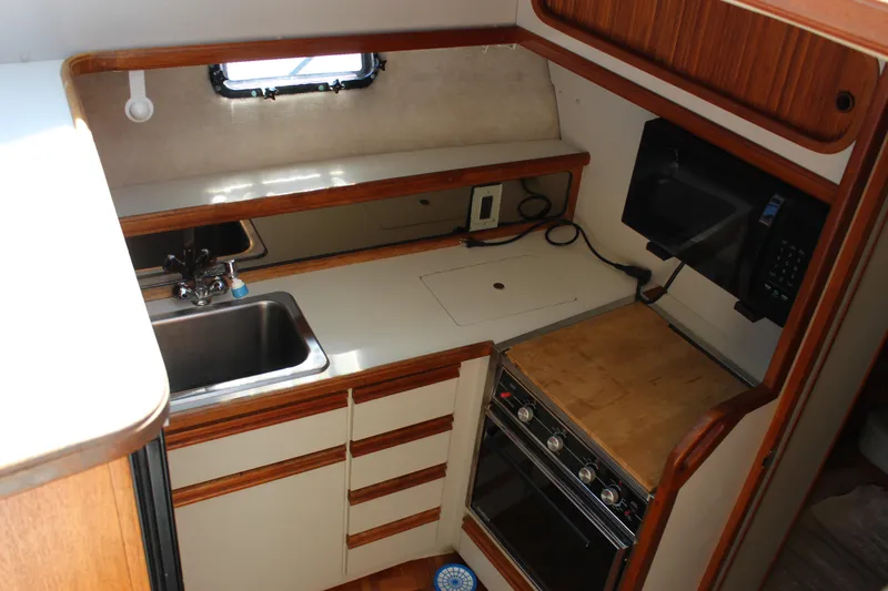 Slide: The Image of 1990 Carver 3207 Aft Cabin Motor Yacht kitchen with sink, stove, and microwave. - 18