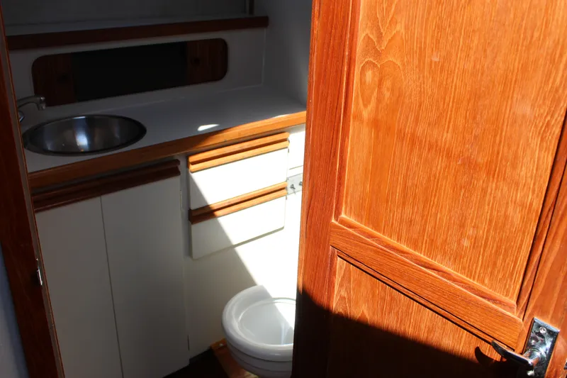 Slide: The Image of 1990 Carver 3207 Aft Cabin Motor Yacht bathroom with wooden door and sink. - 22
