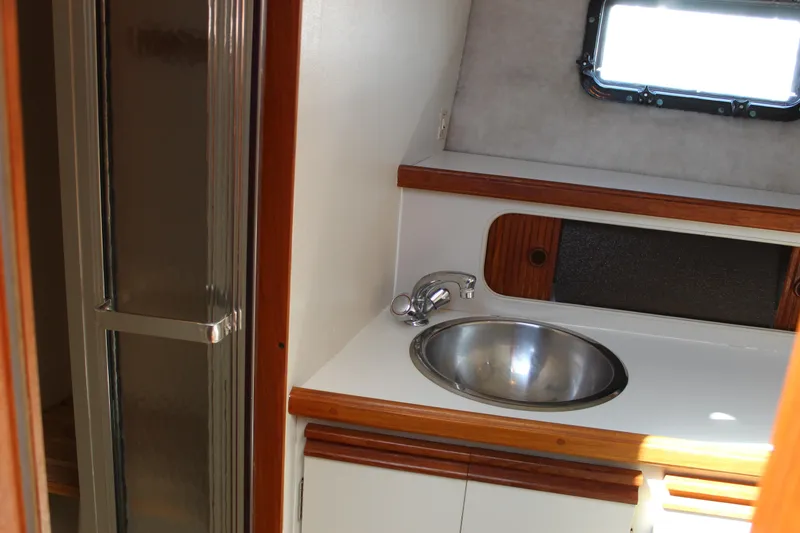 Slide: The Image of 1990 Carver 3207 Aft Cabin Motor Yacht bathroom with sink and shower. - 23