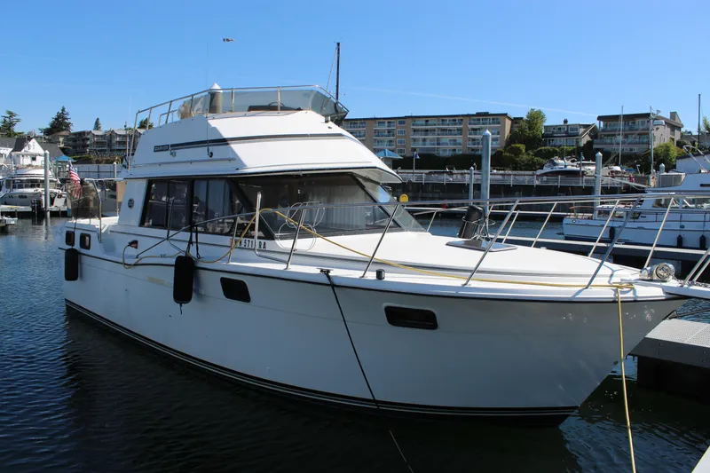Slide: The Image of 1990 Carver 3207 Aft Cabin Motor Yacht docked at marina under clear blue sky. - 3