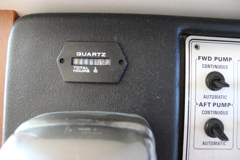 Slide: The Image of Control panel of a 1990 Carver 3207 Aft Cabin Motor Yacht, showing hour meter and pump switches. - 34