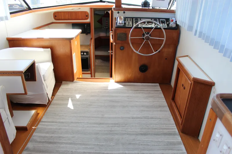 Slide: The Image of 1990 Carver 3207 Aft Cabin Motor Yacht interior with helm, wood finish, and seating area. - 36