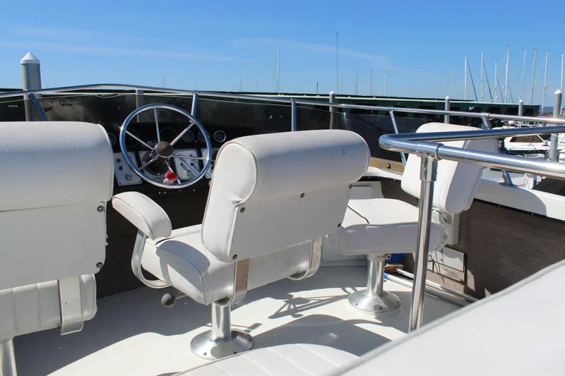Slide: The Image of 1990 Carver 3207 Aft Cabin Motor Yacht helm with white seating and steering wheel. - 38