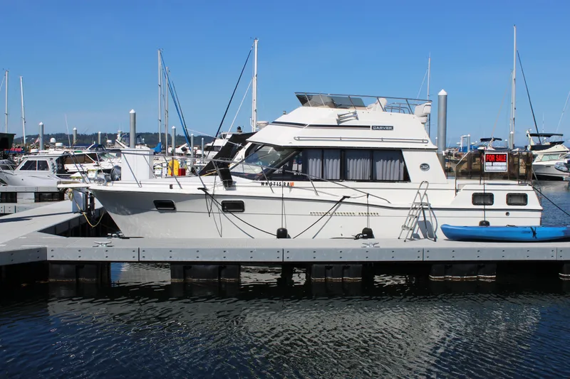 Slide: The Image of 1990 Carver 3207 Aft Cabin Motor Yacht docked, for sale sign visible. - 6
