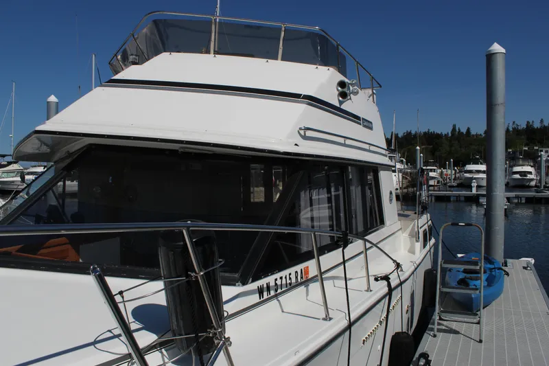 Slide: The Image of 1990 Carver 3207 Aft Cabin Motor Yacht docked at marina under clear blue sky. - 8
