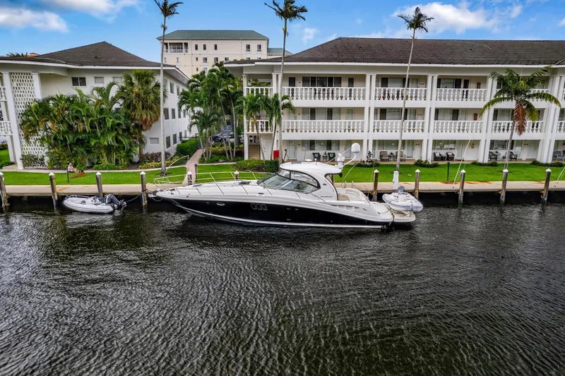 Slide: The Image of 2008 Sea Ray 44 Sundancer yacht docked by waterfront apartments. - 48