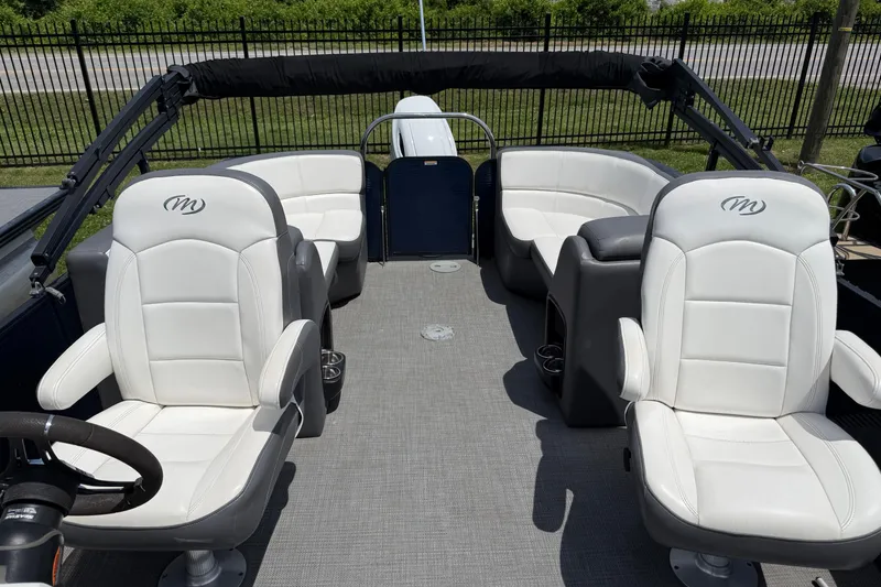 Slide: The Image of 2022 Manitou Aurora LE boat interior with white seating and gray flooring. - 9