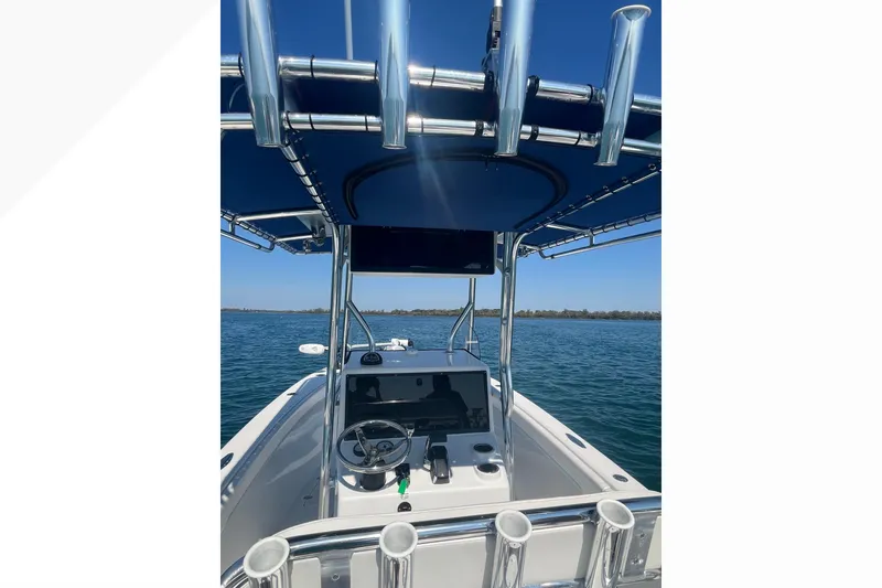 Slide: The Image of 2023 Bluewater Sportfishing 23t boat on water, featuring sleek console and rod holders. - 10