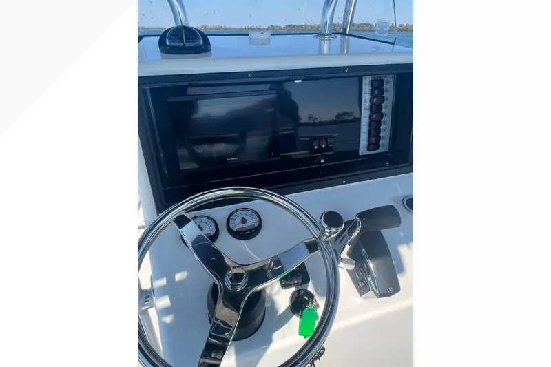 Slide: The Image of 2023 Bluewater Sportfishing 23t boat dashboard with steering wheel and navigation controls. - 11