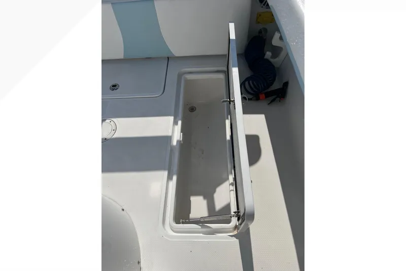 Slide: The Image of Open storage compartment on 2023 Bluewater Sportfishing 23t boat deck. - 21