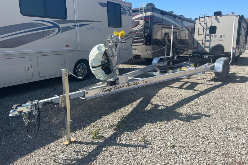 Slide: The Image of Boat trailer for 2023 Bluewater Sportfishing 23t, parked on gravel near RVs. - 24