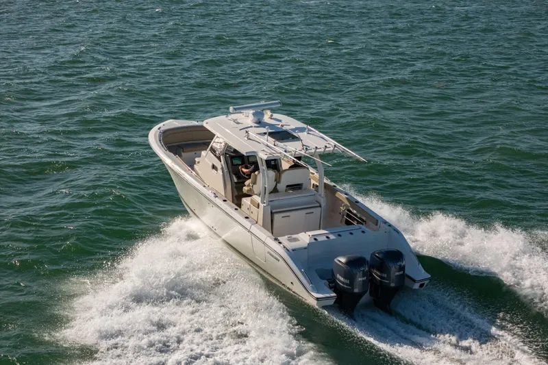 Slide: The Image of 2018 Pursuit S 328 Sport boat cruising on open water with twin engines. - 11