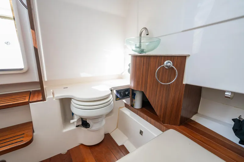 Slide: The Image of 2018 Pursuit S 328 Sport boat bathroom with wooden accents and modern fixtures. - 17
