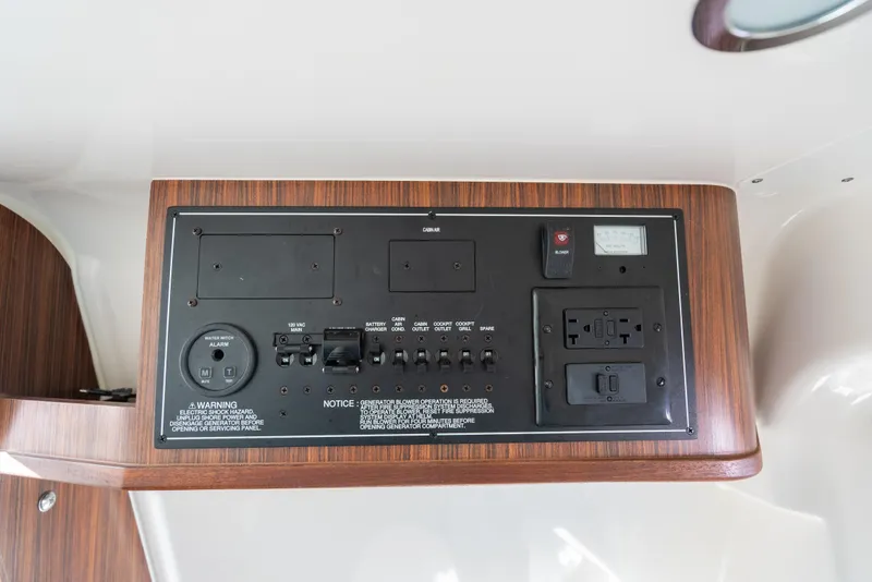 Slide: The Image of Control panel of 2018 Pursuit S 328 Sport boat with wood finish and various switches. - 18