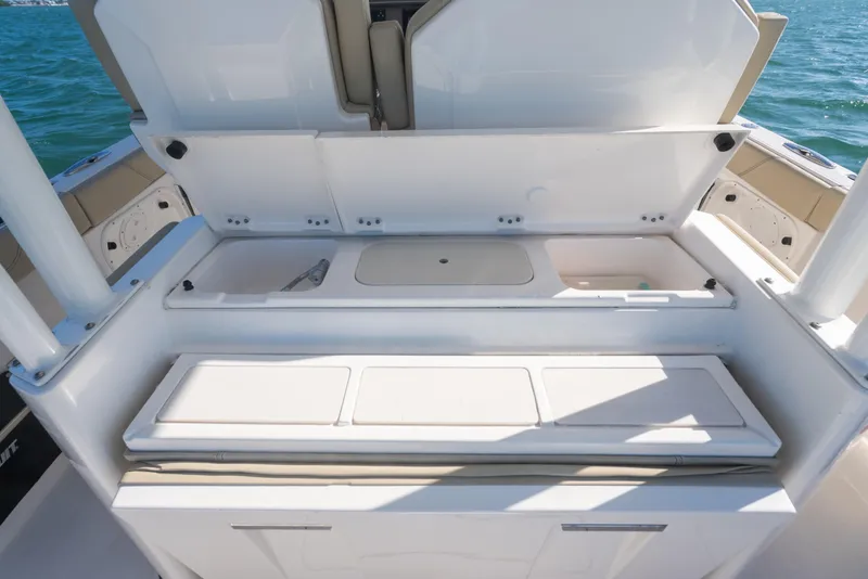 Slide: The Image of 2018 Pursuit S 328 Sport boat with open storage compartments on deck. - 26