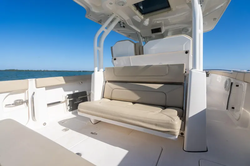 Slide: The Image of 2018 Pursuit S 328 Sport boat interior with beige seating and ocean view. - 28