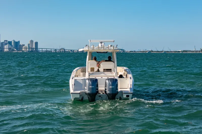 Slide: The Image of 2018 Pursuit S 328 Sport boat cruising on ocean with city skyline in background. - 3