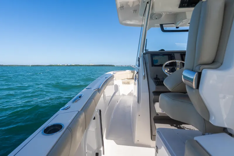 Slide: The Image of 2018 Pursuit S 328 Sport boat interior with ocean view and clear blue sky. - 30