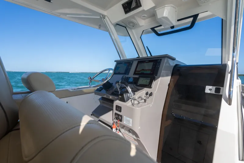 Slide: The Image of Interior view of 2018 Pursuit S 328 Sport boat cockpit with ocean backdrop. - 32