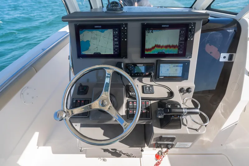 Slide: The Image of Helm of 2018 Pursuit S 328 Sport boat with navigation screens and controls. - 34
