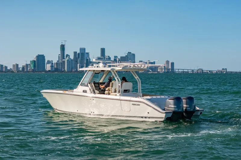 Slide: The Image of 2018 Pursuit S 328 Sport boat cruising near city skyline on a sunny day. - 4