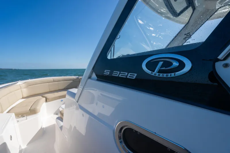 Slide: The Image of 2018 Pursuit S 328 Sport boat on open water, showcasing sleek design and logo. - 41