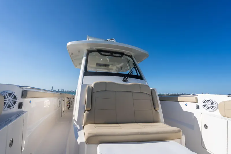 Slide: The Image of 2018 Pursuit S 328 Sport boat with beige seating, clear blue sky background. - 43